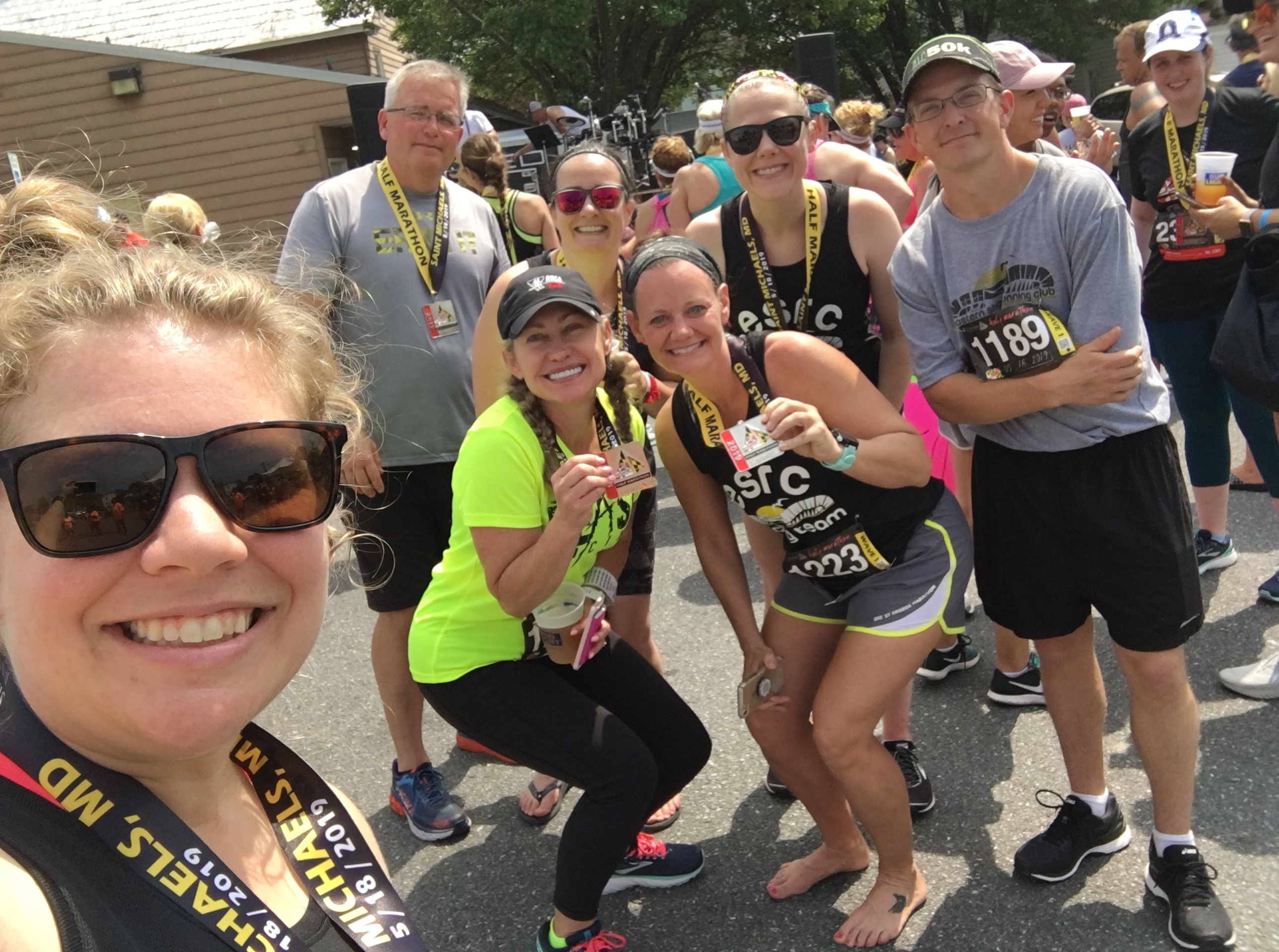 Eastern Shore Running Club members in a selfie taken by Vanessa Junkin. People are holding finisher medals. 