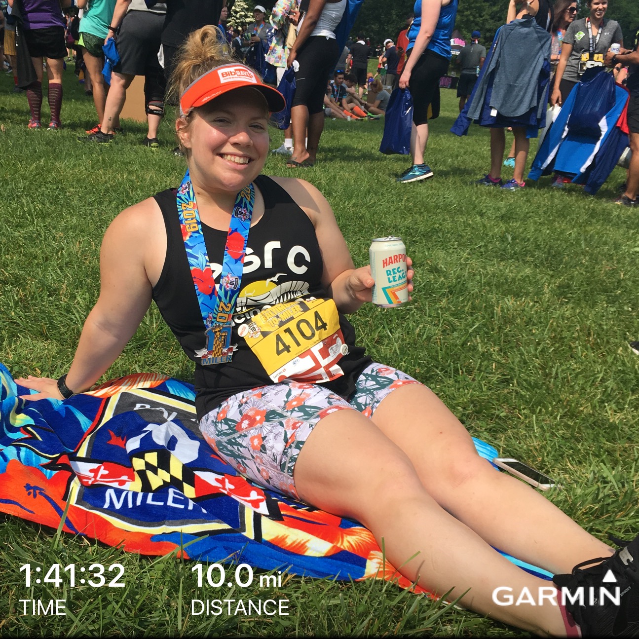 Vanessa relaxing on beach towel with beer after Baltimore 10 Miler. 