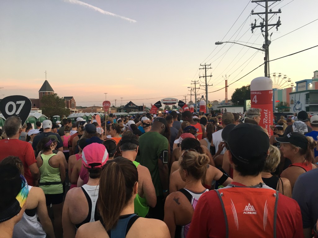Large group of runners in the corral facing the starting line. 