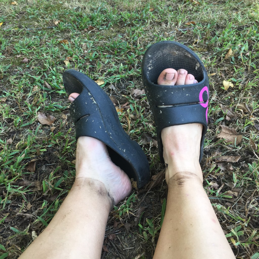 Vanessa's dirty feet in the OOFOS slides.