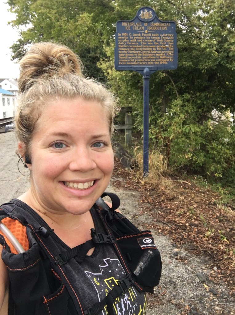 Vanessa gets a selfie next to the marker for the Birthplace of Commercial Ice Cream Production. 