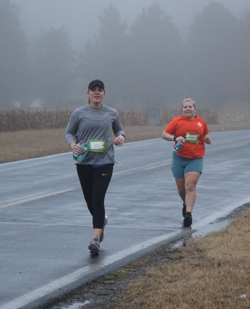 Vanessa Junkin runs slightly behind Kate James on a foggy day. 