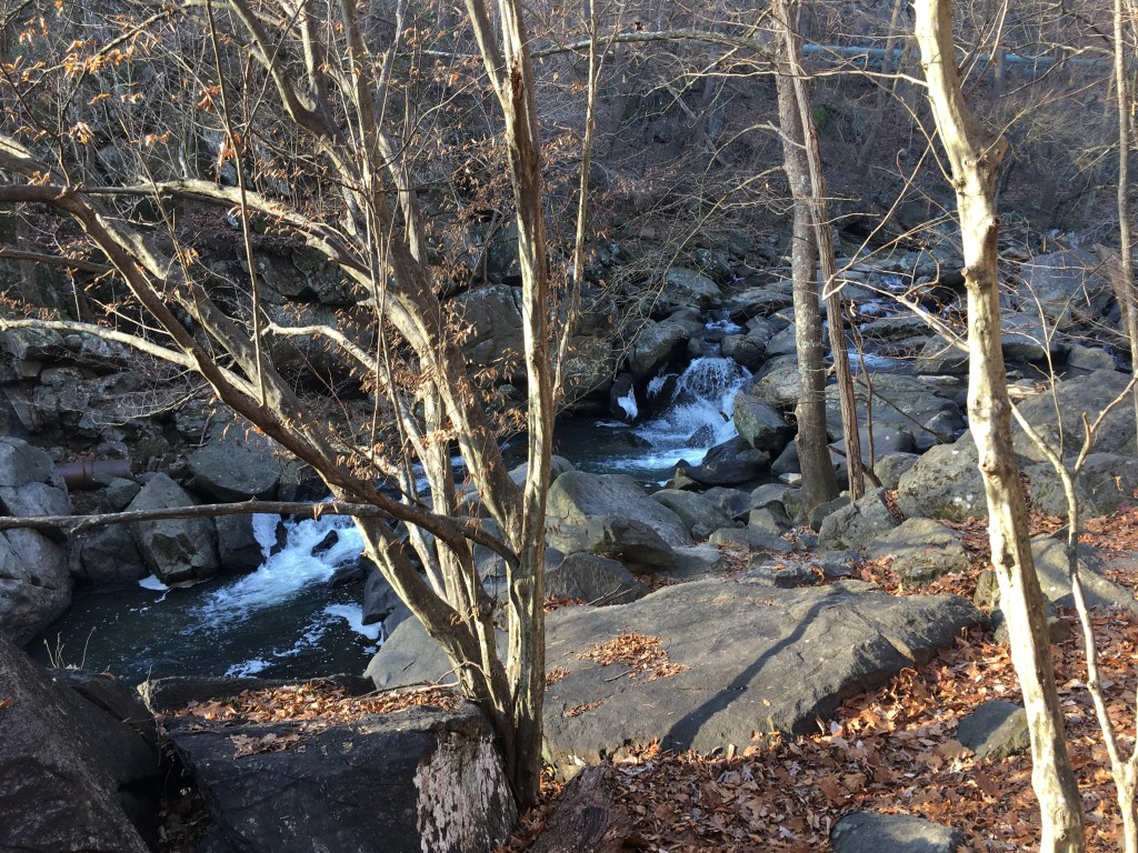 A small waterfall is shown, with rocks on either side. 
