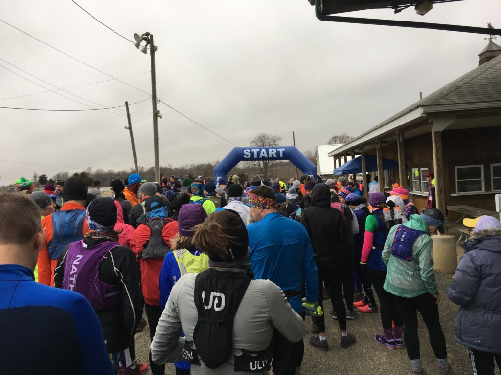 Runners line up behind "START" on an inflatable blue arch. 