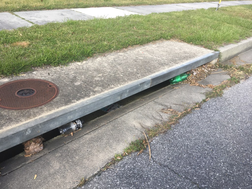 Trash is shown in a storm drain. 