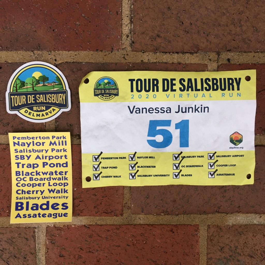 Race bib with all the segments checked off on the right, with Tour de Salisbury stickers on the left. The top sticker is the event logo and the bottom one lists all the segments. 