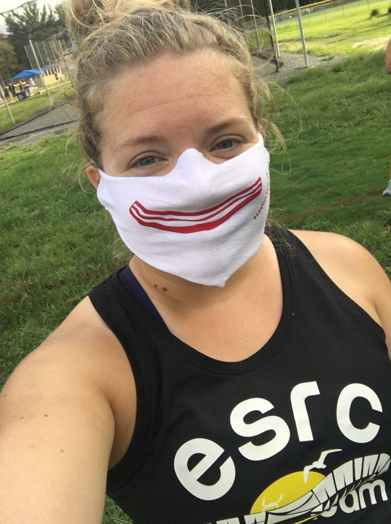 Vanessa Junkin wears a cloth mask with a piece of bacon in the shape of a smile on it. 