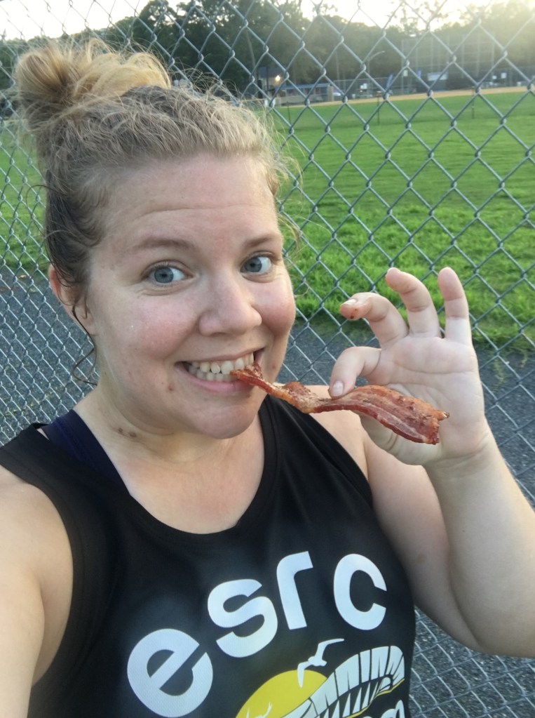 Vanessa Junkin holds a piece of bacon as she eats the other end. 