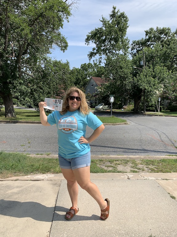 Vanessa Junkin poses in blue Tour de Salisbury shirt with completed race bib. 