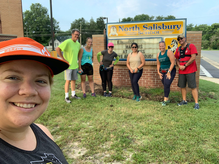 Group of runners posing by North Salisbury Elementary sign. 