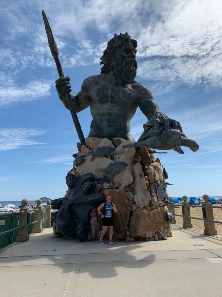 Vanessa Junkin posing for photo with large King Neptune statue in Virginia Beach. 