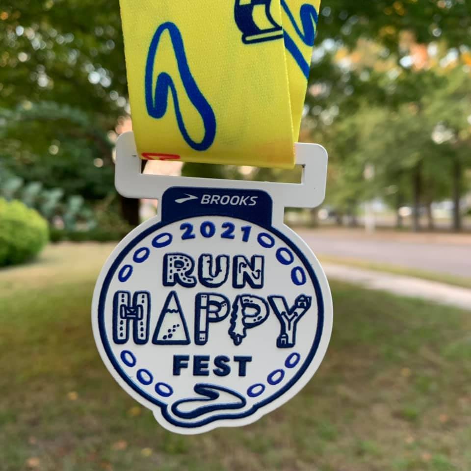 Run Happy Fest medal (white with blue writing and yellow ribbon)
