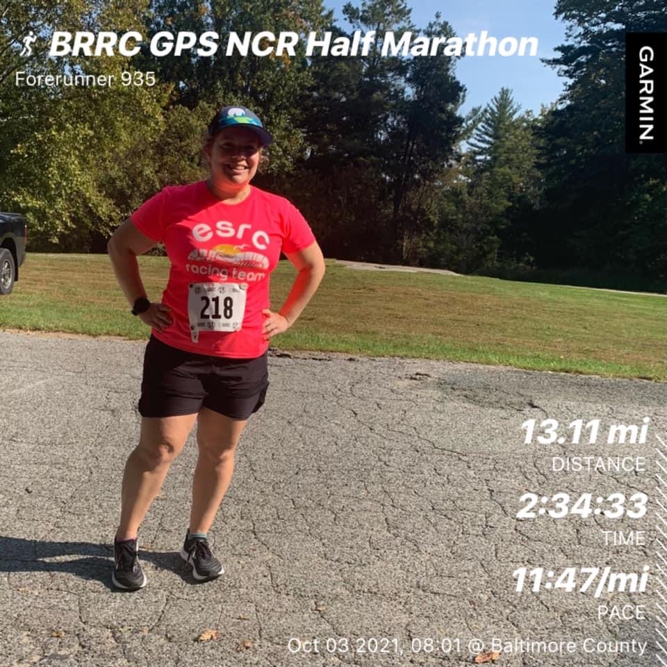 Vanessa Junkin poses in running clothes. Text says "BRRC GPS NCR Half Marathon," "13.11 mi - Distance," "2:34:33 - Time," and "11:47/mi - Pace." 
