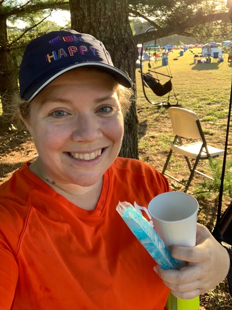 Selfie of Vanessa Junkin holding blue ice pop and cup. 