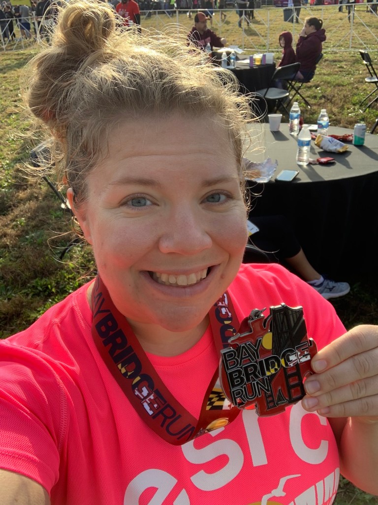 Vanessa Junkin holds up a Bay Bridge Run medal. 