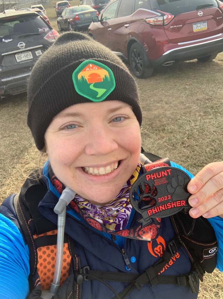 Selfie of Vanessa Junkin holding PHUNT 25K race medal. 