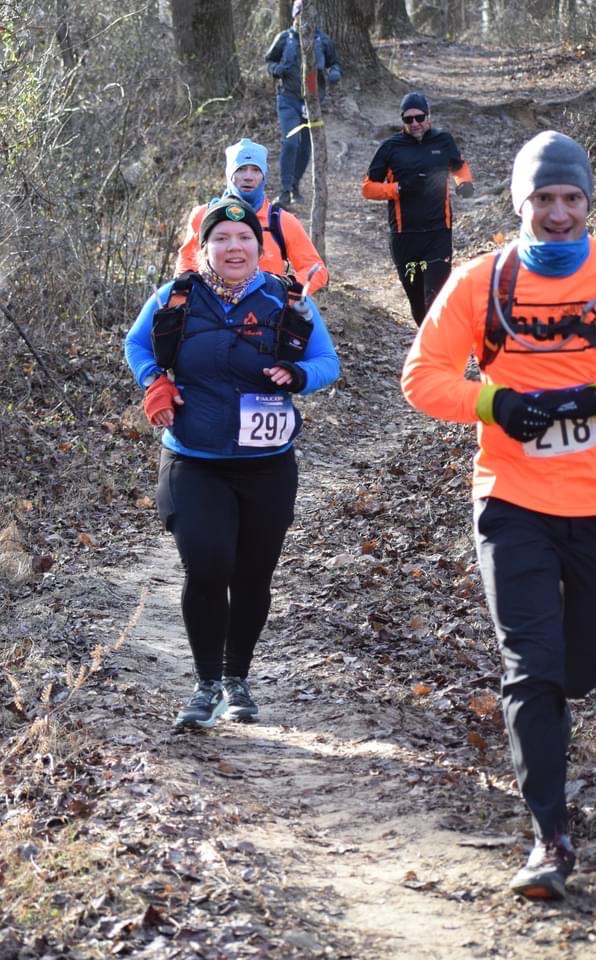 Runners coming down a wooded hill, including Vanessa Junkin.