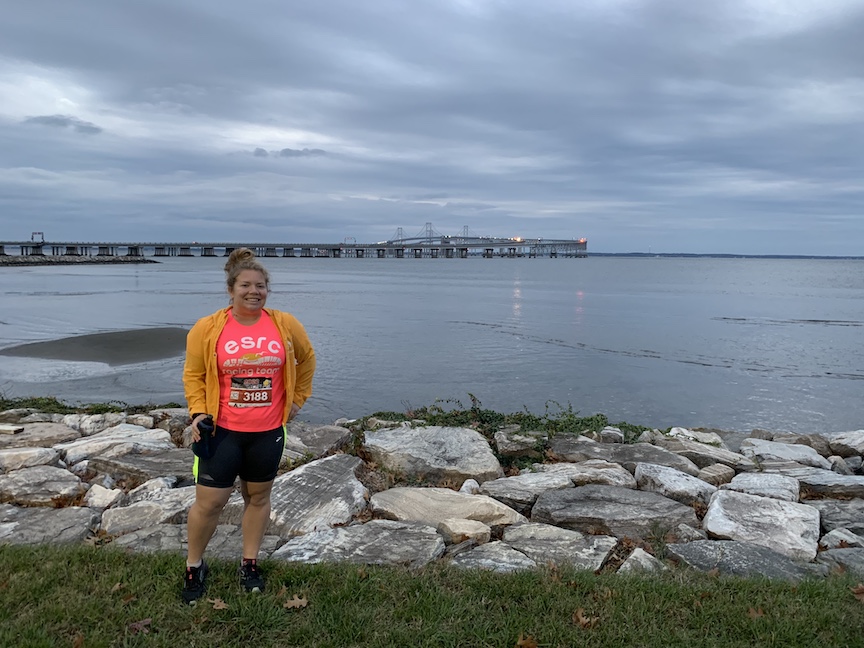Vanessa Junkin stands in front of the Chesapeake Bay, with the Bay Bridge in the background. 