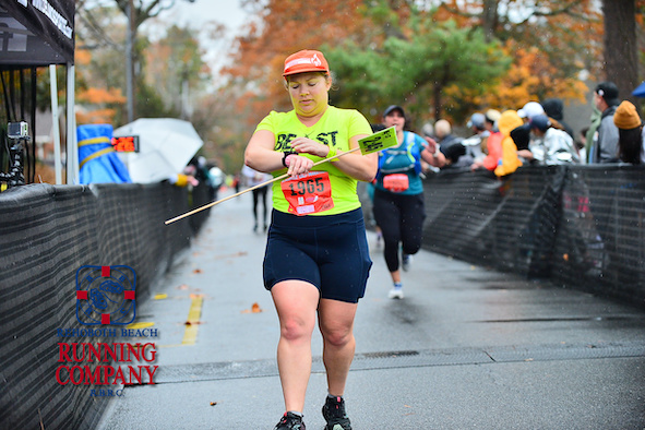 Vanessa Junkin stops and checks her watch after crossing the finish line. 