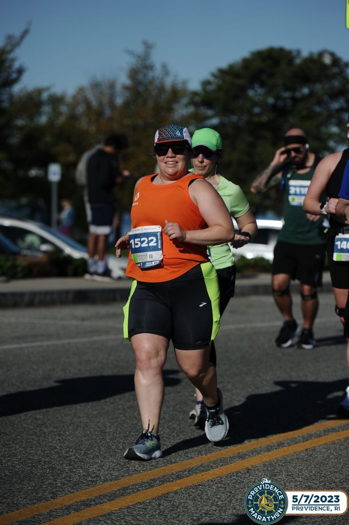 Female runner moving forward with other runners behind her. 