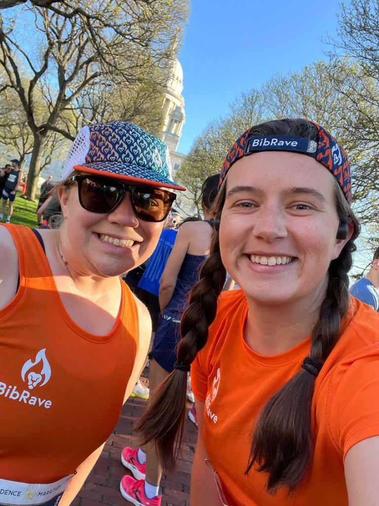 Selfie of two female runners in orange shirts. 