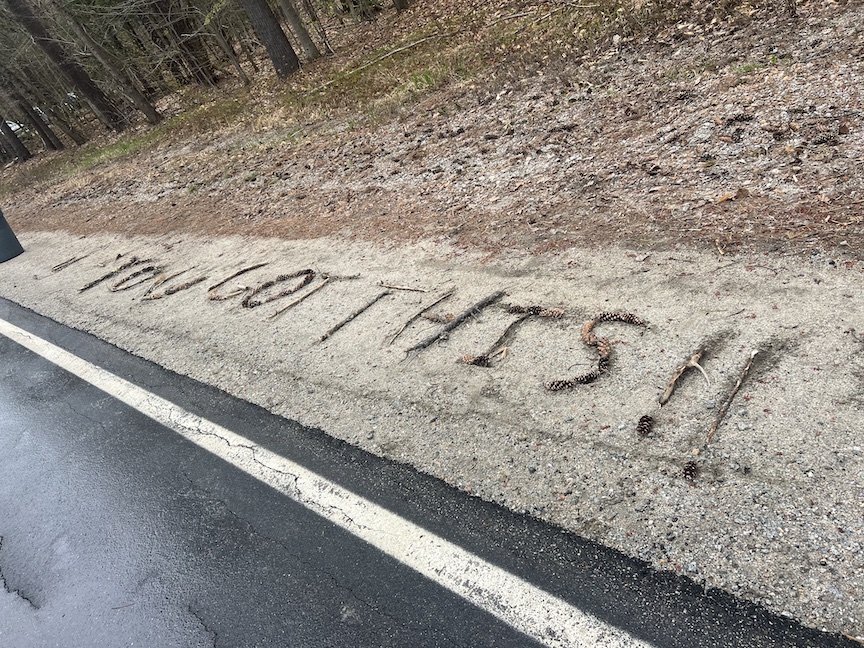 Sticks spell out "YOU GOT THIS!!" on the side of the road. 
