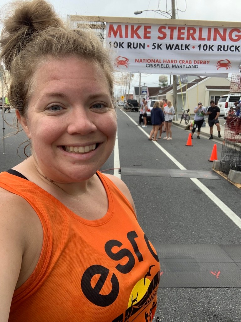 Selfie of Vanessa Junkin with Mike Sterling crab pot finish arch/banner in the background.