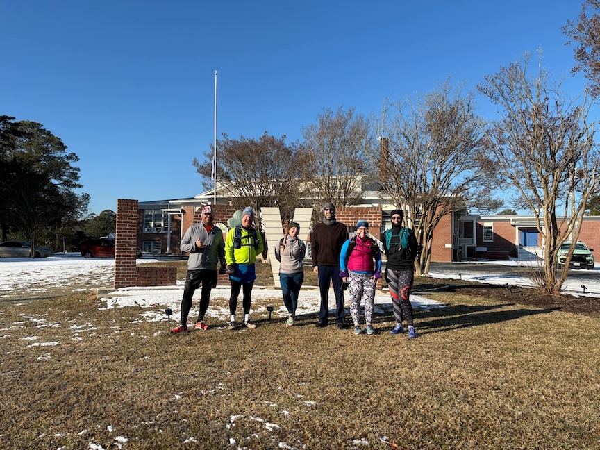 Six runners pose in front of the "LOVE" sign in Onancock. 