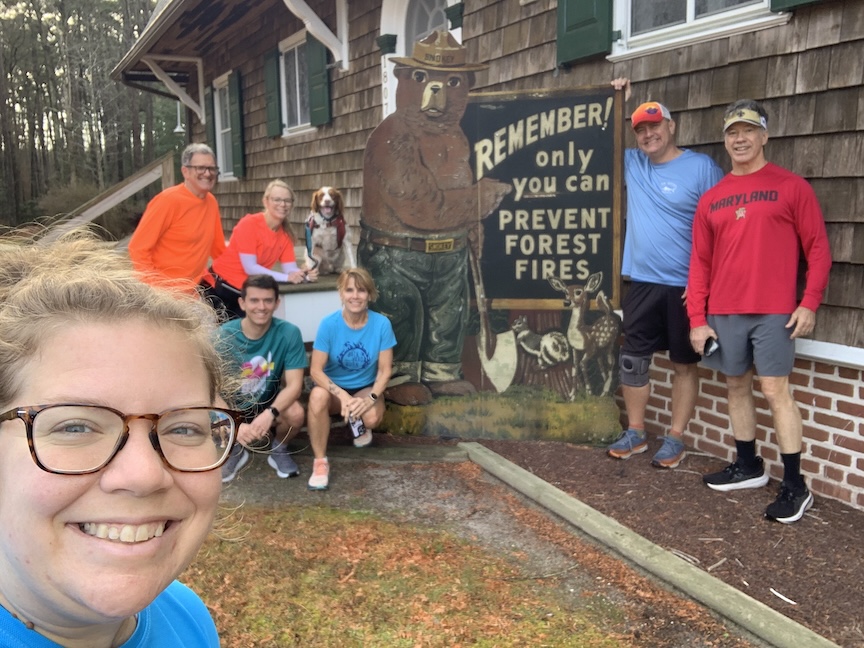 Group selfie with Smokey the Bear sign that says "Remember! Only you can prevent forest fires."