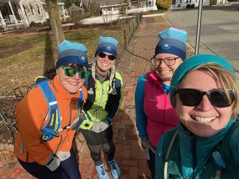 Group of four running friends smiling for a selfie. 