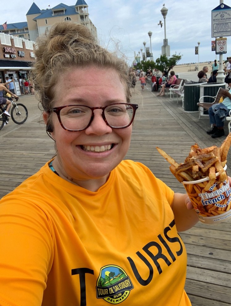 Selfie of Vanessa wearing a "TOURIST" shirt and holding a cup of Thrasher's french fries