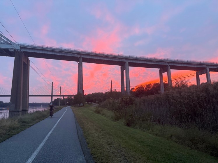 Colorful sunset with paved trail and showing bridge. 