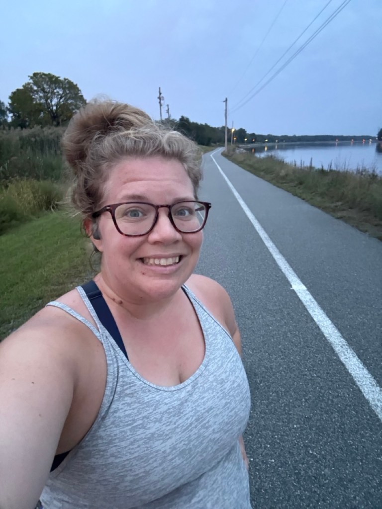 Selfie of female runner on paved trail. 