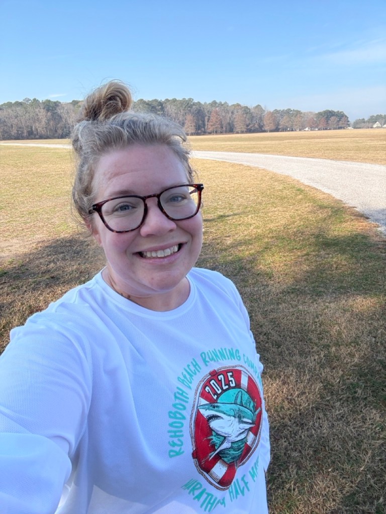 Selfie of Vanessa Junkin in white long-sleeved shirt in a park. 