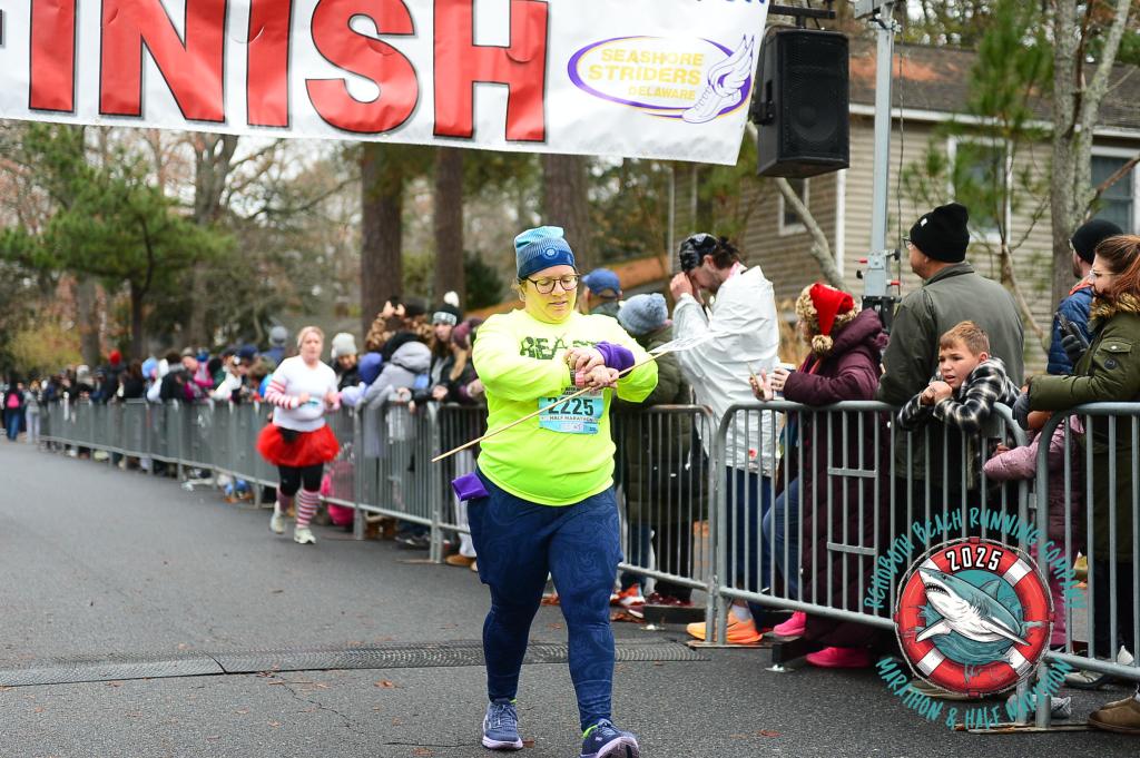 Vanessa Junkin, a pacer in the Rehoboth Beach Seashore Half Marathon, checks her watch after crossing the finish line.