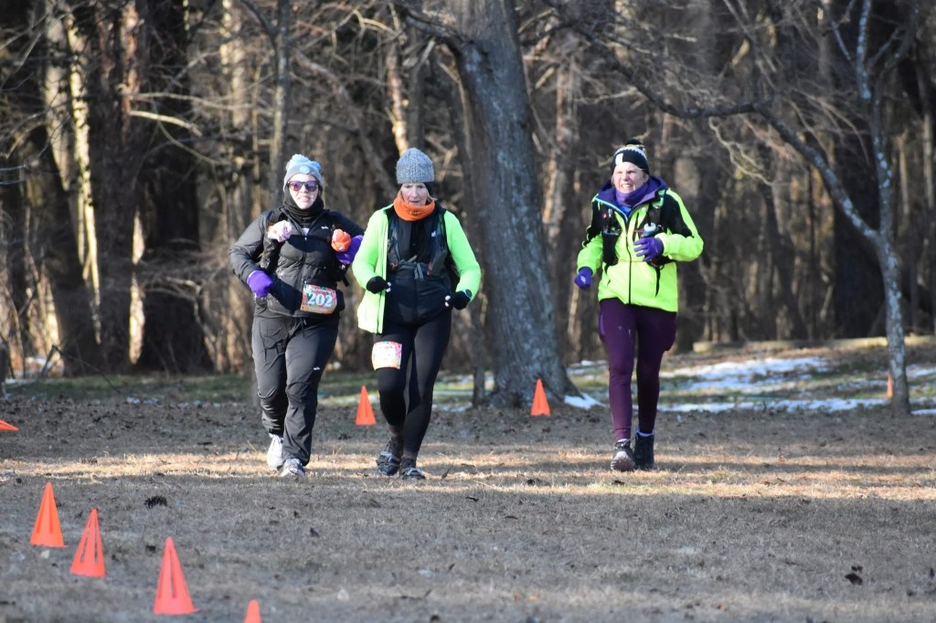 Three bundled-up runners running outside.