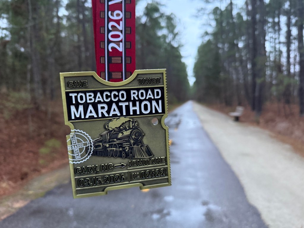 Tobacco Road Marathon finisher medal with the course in the background. 