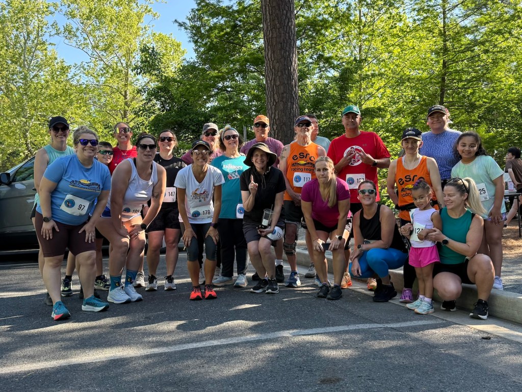Large group of runners poses for a photo at a race.
