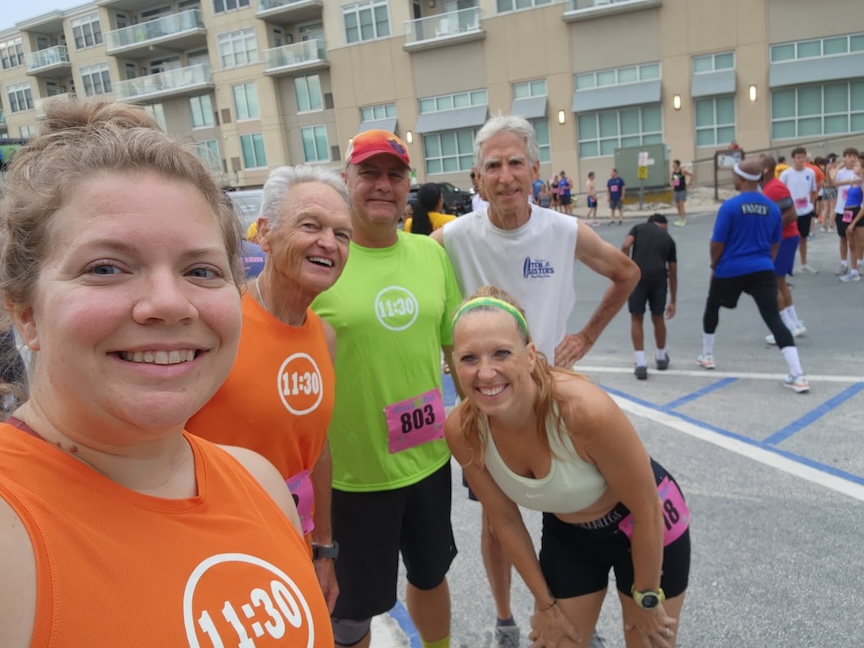 Group of five runners posing for a photo